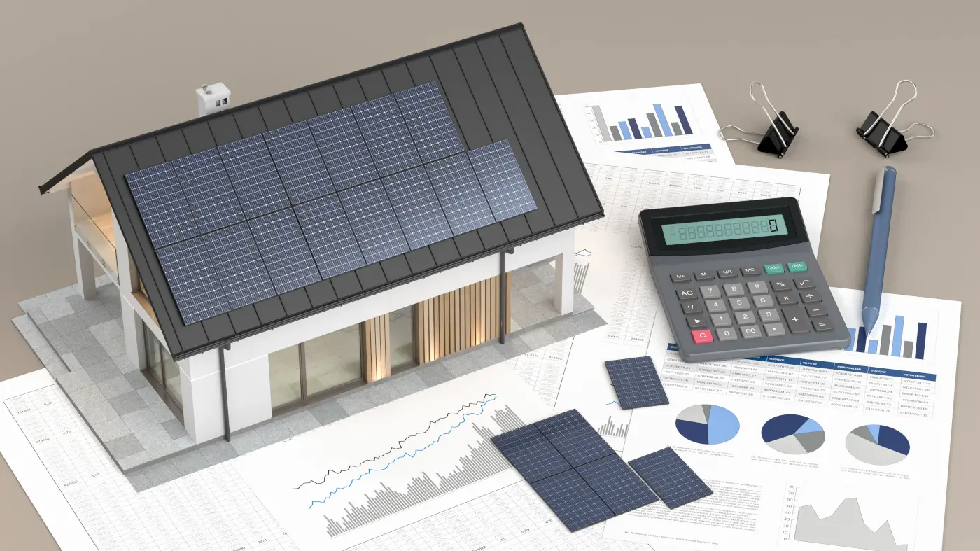 Maison avec panneaux photovoltaiques et une calculatrice