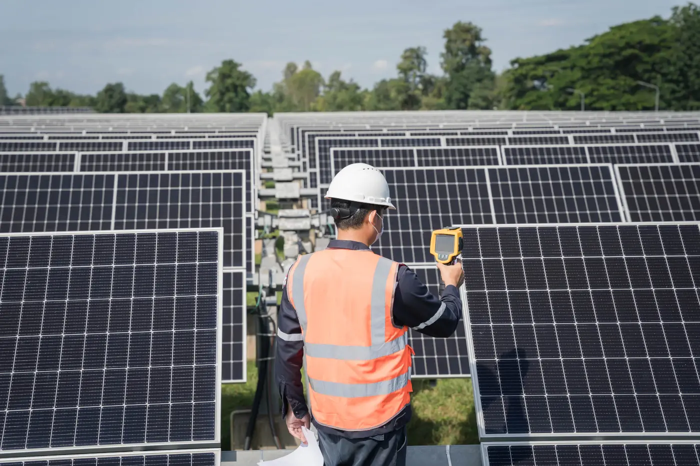 homme dans un champ de panneaux solaire