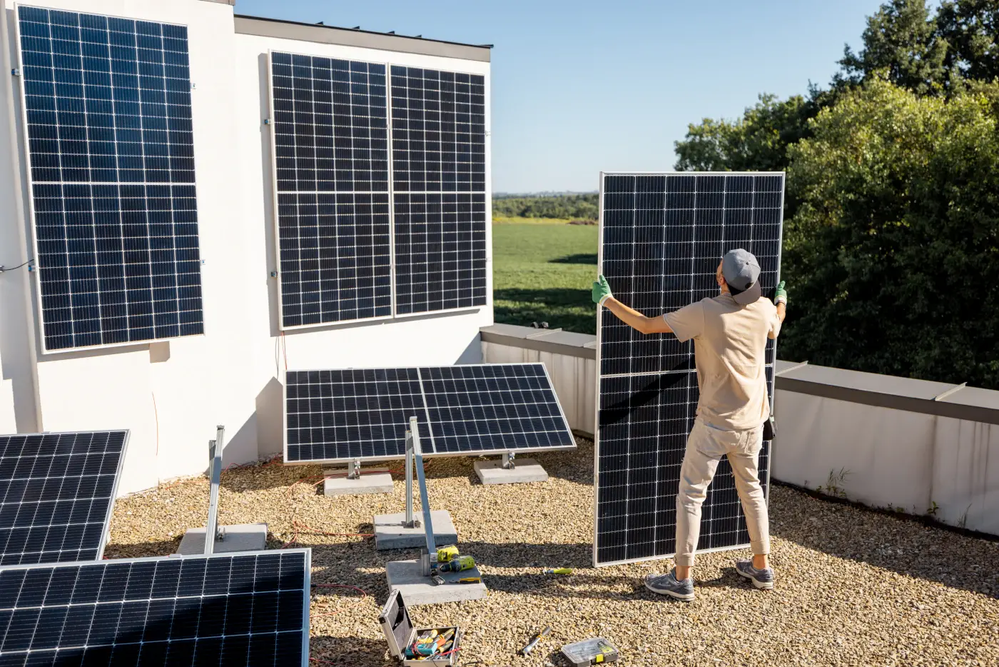 Un homme qui installe une centrale photovoltaique sur le toit de sa maison.