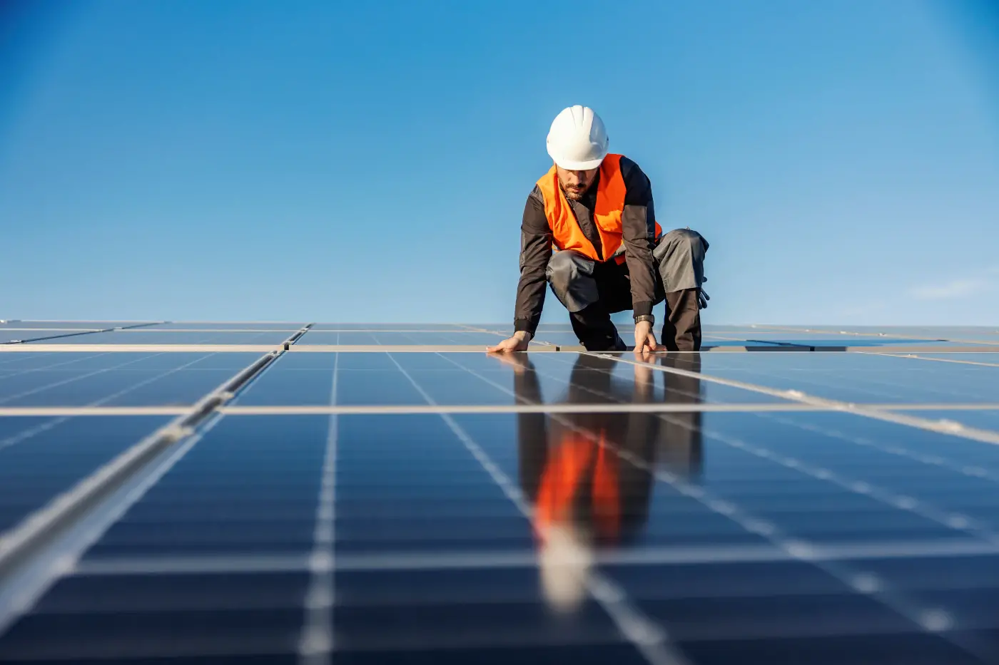 ouvrier installant des panneaux solaires sur un toit