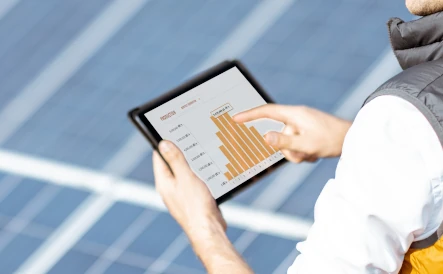 dame tenant une tablette qui affiche le taux de production des panneaux solaires